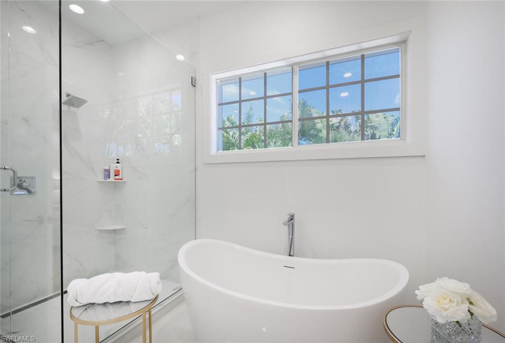 888 10th Street South, Unit 101 Naples, FL 34102 - Photo 28 of 44 a white bath tub sitting next to a toilet