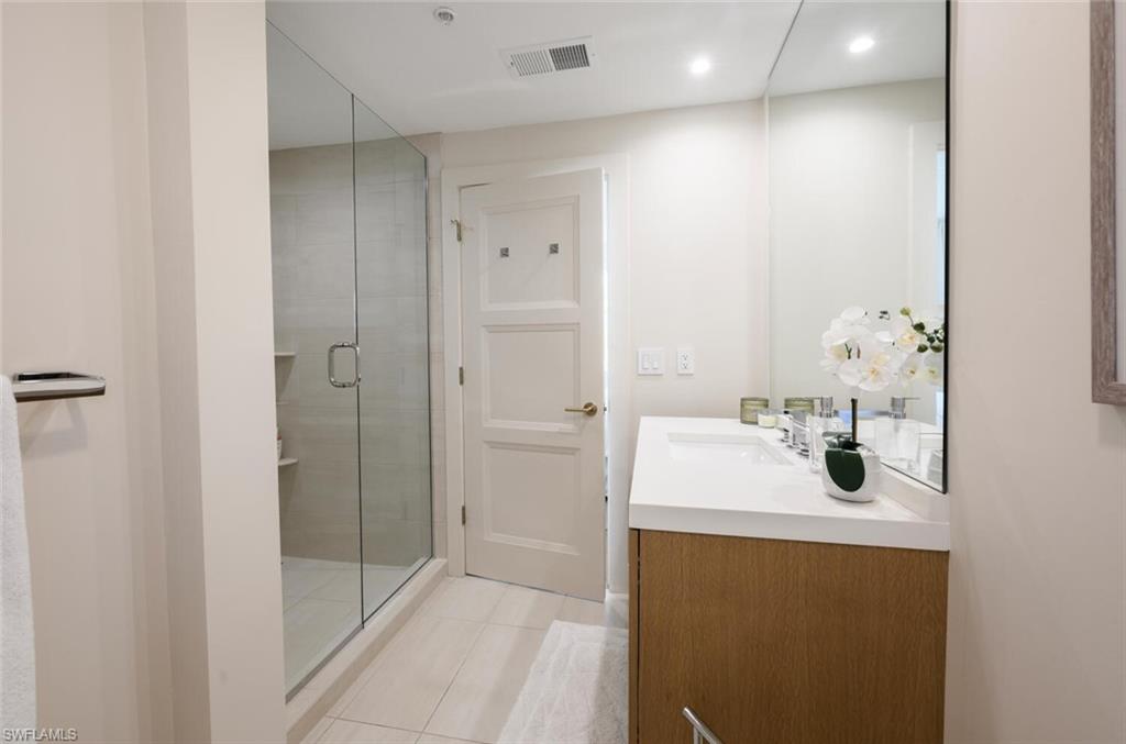 888 10th Street South, Unit 101 Naples, FL 34102 - Photo 32 of 44 a bathroom with a sink a mirror and shower