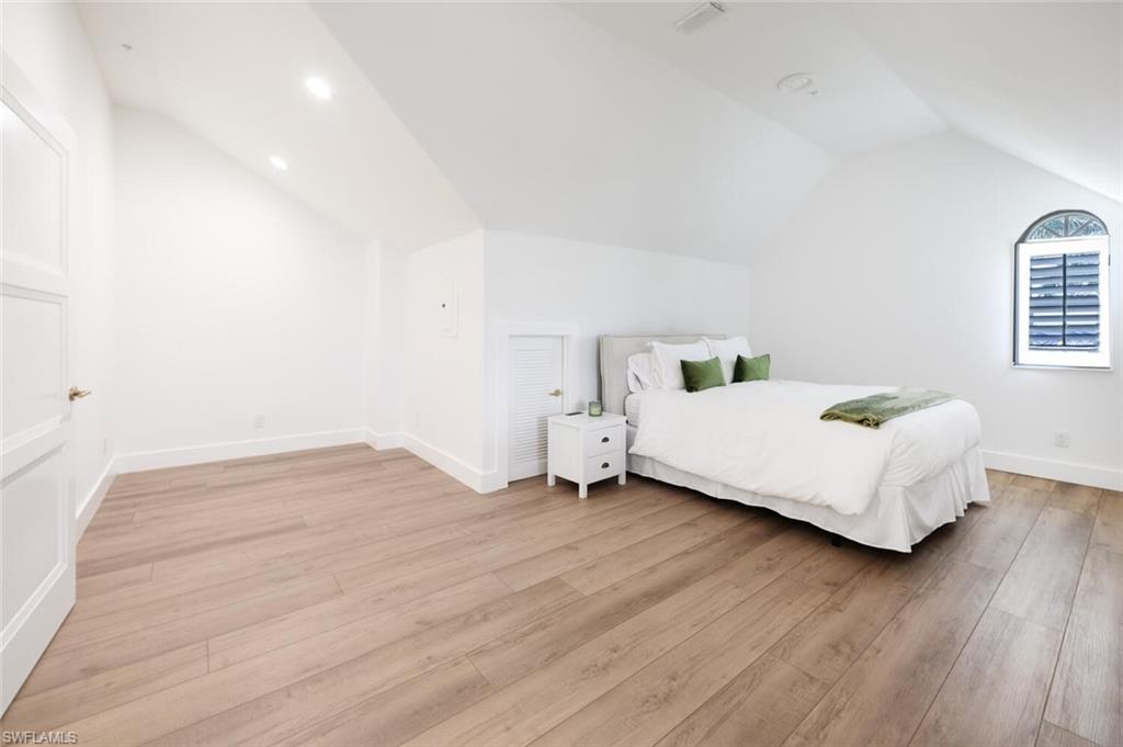 888 10th Street South, Unit 101 Naples, FL 34102 - Photo 35 of 44 a bedroom with a bed and wooden floor
