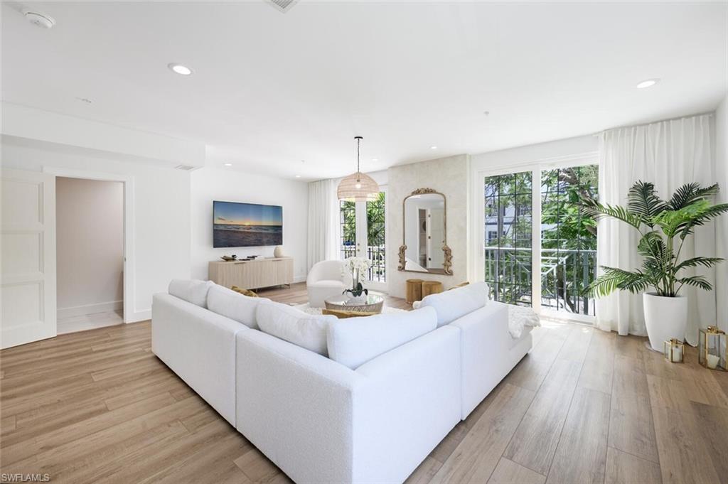 888 10th Street South, Unit 101 Naples, FL 34102 - Photo 8 of 44 a living room with furniture large window and wooden floor
