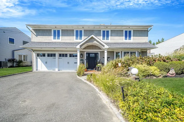a front view of a house with a garden and balcony