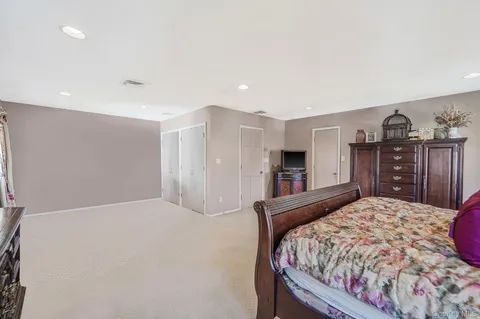 a bedroom with a large bed and a dresser