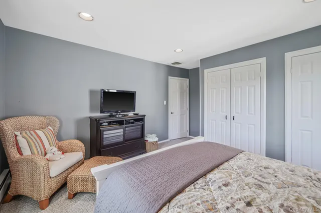 a bedroom with furniture and a flat screen tv