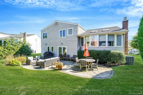 a view of a house with backyard sitting area and garden