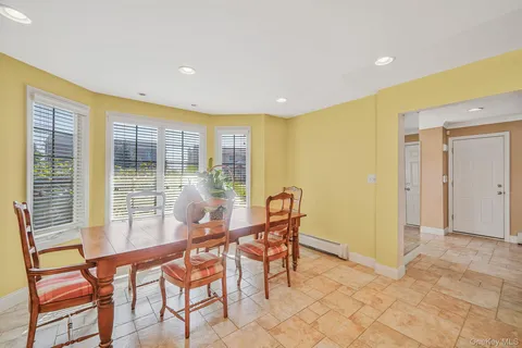 a dining room with furniture and large windows