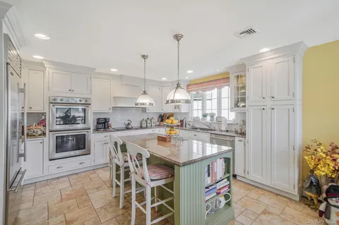 a kitchen with a sink a counter top space stainless steel appliances and cabinets