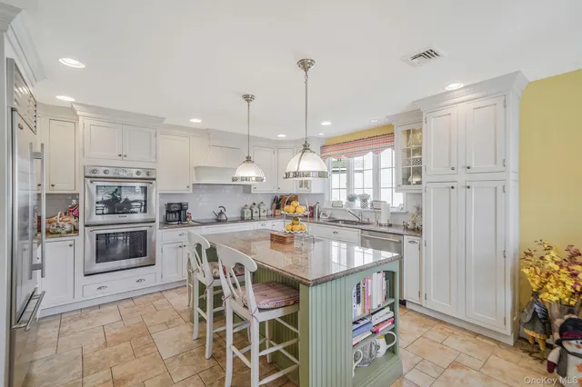 a kitchen with a sink a counter top space stainless steel appliances and cabinets
