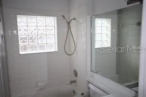 a bathroom with a bath tub with a shower