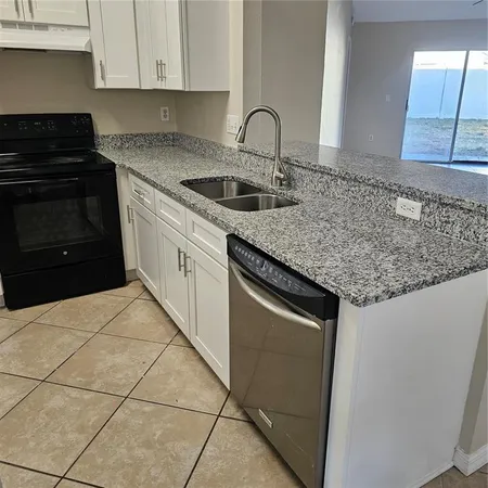 a kitchen with granite countertop a sink and a stove