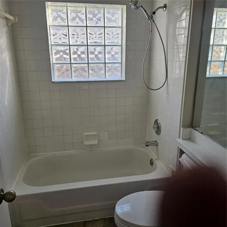 a bathroom with a bath tub and a window