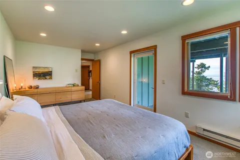 a bedroom with a bed and a dresser next to a window