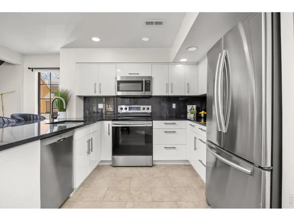 a kitchen with kitchen island stainless steel appliances cabinets a sink and a counter top space