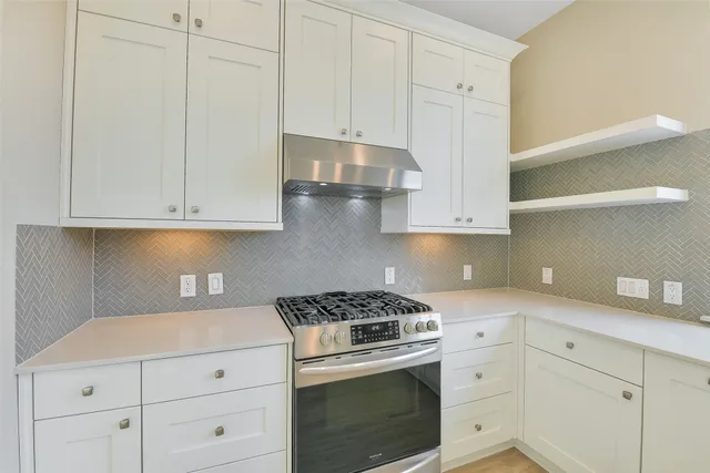 a kitchen with white cabinets and appliances