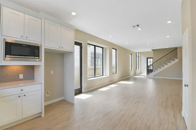 a view of a kitchen with wooden floor and electronic appliances