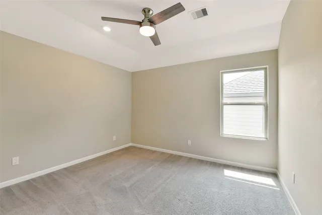 an empty room with a window and a fan