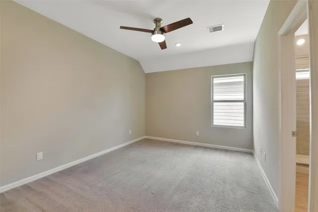 an empty room with a ceiling fan and window
