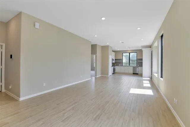 a view of empty room with wooden floor