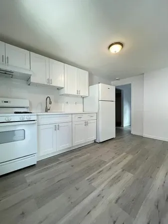 a view of a kitchen with white cabinets and white appliances