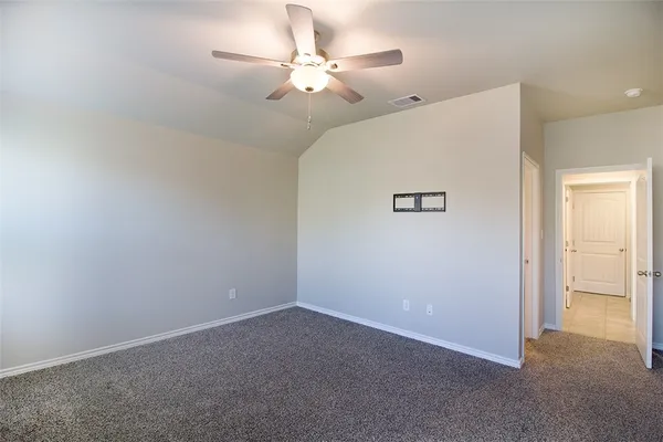 an empty room with a chandelier fan