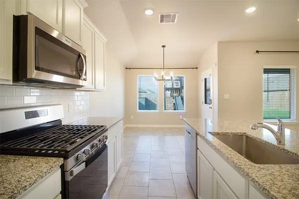 a kitchen with stainless steel appliances granite countertop a sink and a microwave