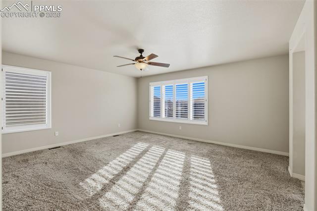 2224 Reed Grass Way Colorado Springs, CO 80915 - Photo 27 of 39 Carpeted spare room with baseboards and ceiling fan