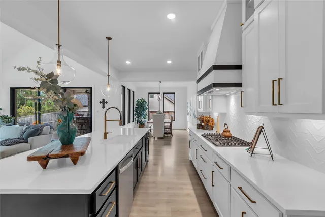 a large kitchen with kitchen island a large counter top space a sink stainless steel appliances and cabinets