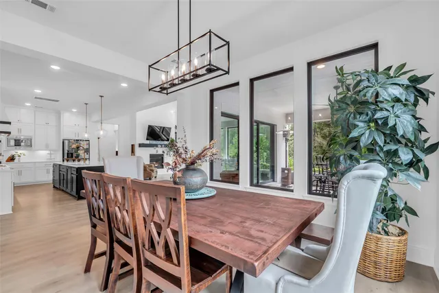 a view of a dining room with furniture a potted plant and wooden floor