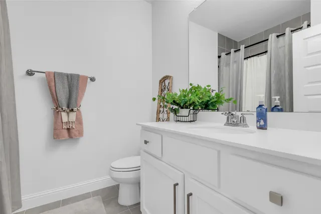 a bathroom with a granite countertop sink a toilet and mirror