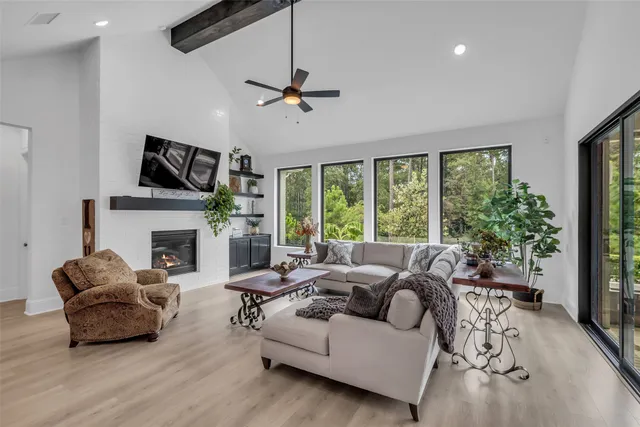 a living room with furniture a fireplace and a large window
