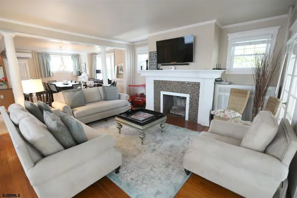 a living room with furniture a fireplace and a flat screen tv