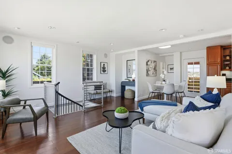 a living room with furniture and paintings on the wall