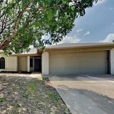 a front view of house with yard and trees in the background