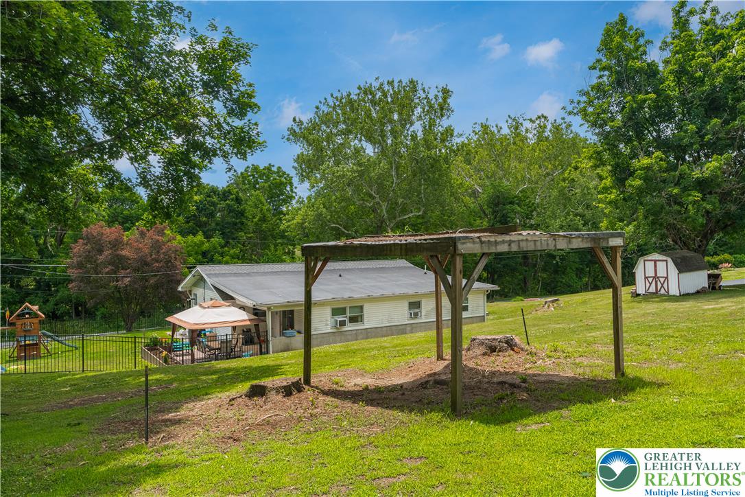 50 Kohls Road Northampton, PA 18067 - Photo 41 of 54 A spacious backyard features a gazebo, playset, and charming shed amidst verdant greenery.