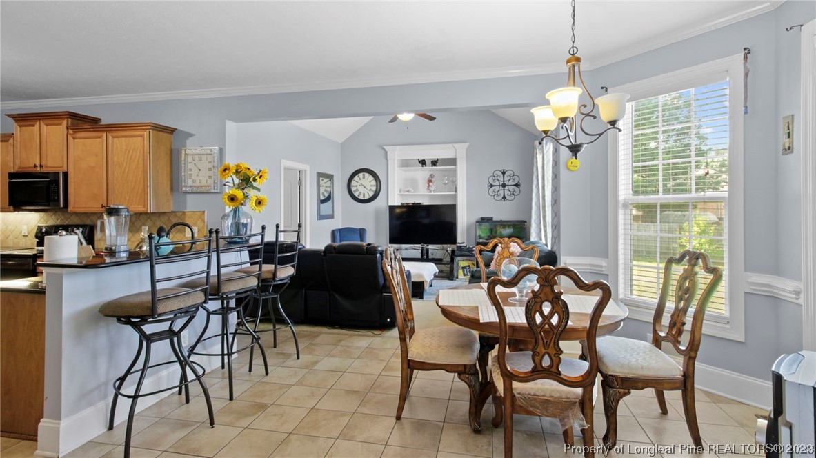 517 St Thomas Road Fayetteville, NC 28311 - Photo 19 of 47 a view of a dining room with furniture a chandelier and large windows