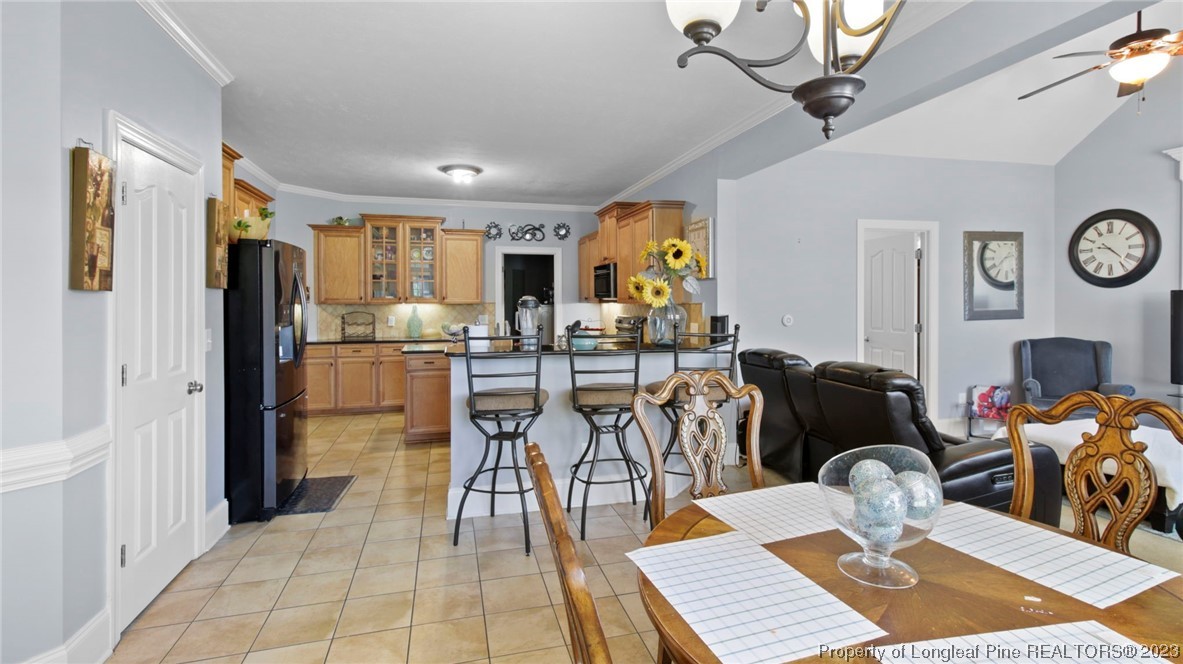 517 St Thomas Road Fayetteville, NC 28311 - Photo 20 of 47 a kitchen with stainless steel appliances kitchen island granite countertop a refrigerator a stove a microwave oven with a dining table and chairs