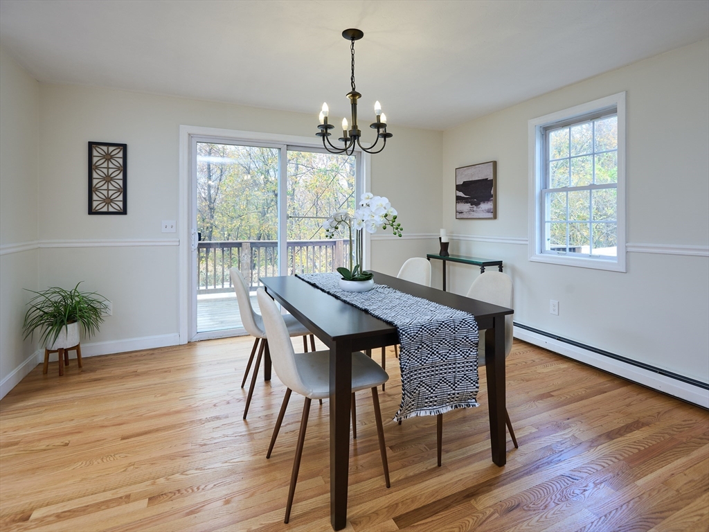33 Wrentham Road Worcester, MA 01602 - Photo 5 of 42 a dining room with wooden floor a chandelier a wooden table and chairs