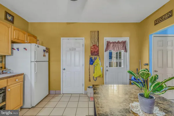 a view of a kitchen with refrigerator and front door