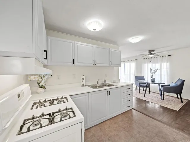 a kitchen with white cabinets and white appliances