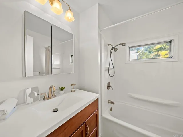 a bathroom with a tub sink and mirror