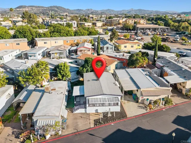 an aerial view of residential houses with outdoor space and parking