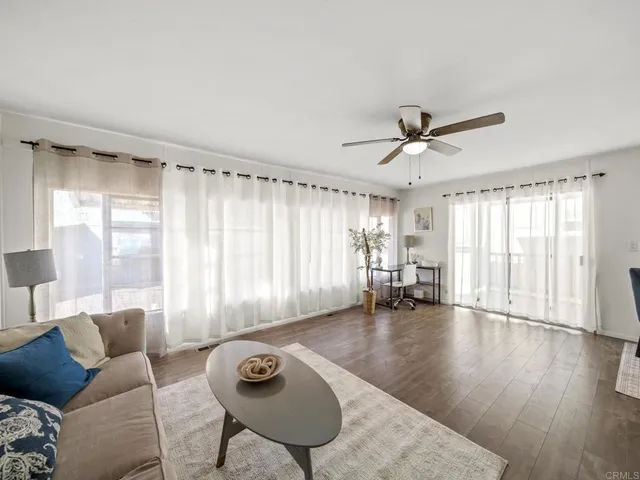a living room with furniture and window with wooden floor