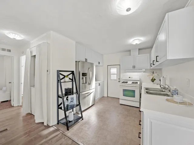 a kitchen with white cabinets and white stainless steel appliances