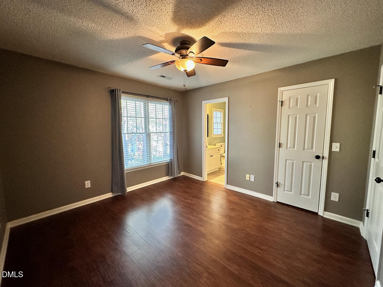 7020 Epping Forest Drive Raleigh, NC 27613 - Photo 12 of 24 a view of an empty room with window and wooden floor