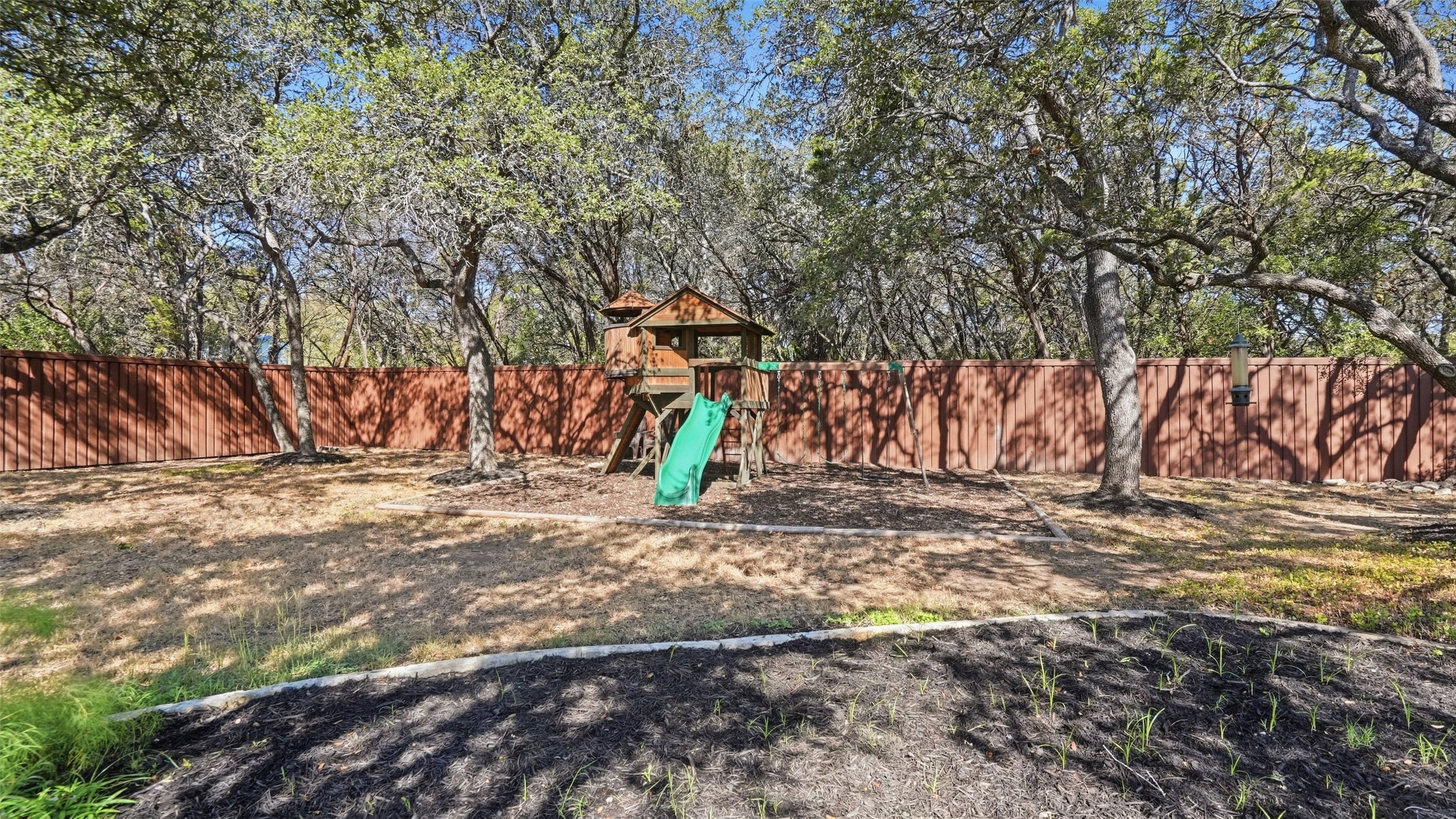 5910 Hudson Bend Road Austin, TX 78734 - Photo 36 of 40 Mature trees shade a spacious backyard fully enclosed by wooden privacy fencing.