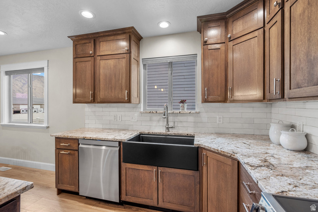 1896 West 800 North Mapleton, UT 84663 - Photo 10 of 55 Kitchen featuring light stone counters, stainless steel appliances, light wood-type flooring, wood finish cabinets, and backsplash