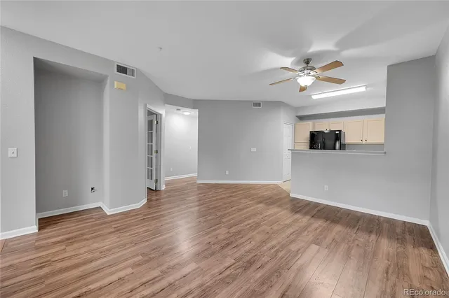 a view of an empty room with window and wooden floor