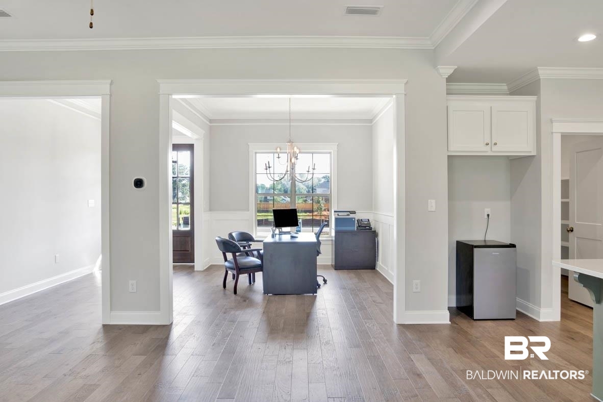 393 Garrison Boulevard Fairhope, AL 36532 - Photo 25 of 40 Dining room with hardwood / wood-style floors, a notable chandelier, and ornamental molding