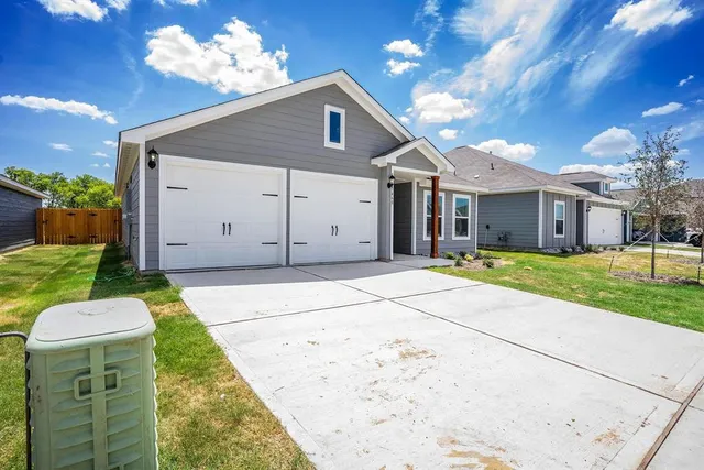 a view of a house with a yard and large tree