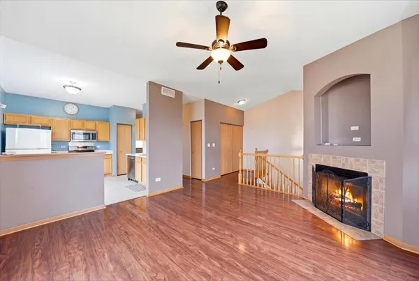 a view of a livingroom with wooden floor and a kitchen