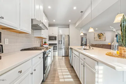 a kitchen with stainless steel appliances granite countertop a sink stove and cabinets